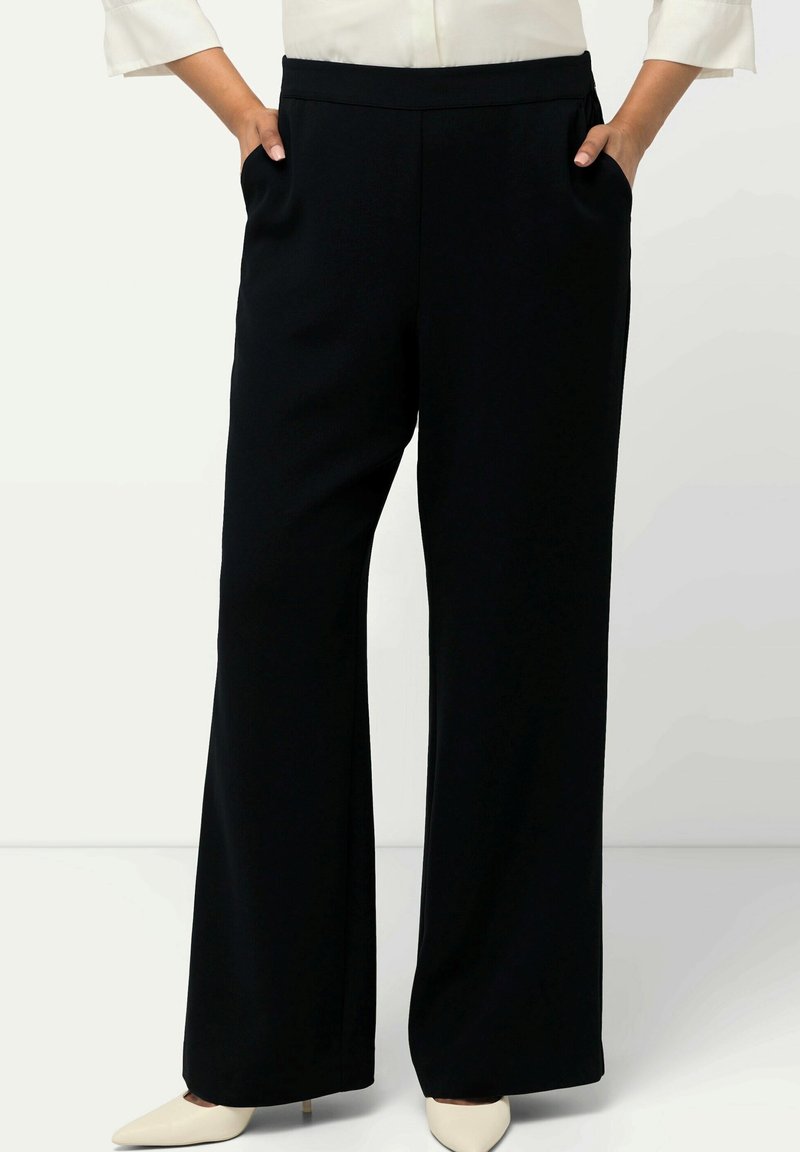 Černé kalhoty s širokými nohavicemi vyrobené z hladkého, lehkého materiálu. Obsahují boční kapsy a pohodlný elastický pás.