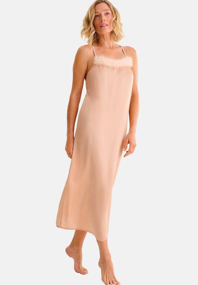 Nuisette en satin nude avec une bordure en plumes le long de l'encolure. Dispose de fines bretelles et d'un design fluide, longueur cheville. Texture douce.