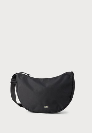 Schwarze halbmondförmige Schultertasche mit verstellbarem Riemen und kleinem grünem Krokodil-Logo vorne in der Mitte.
