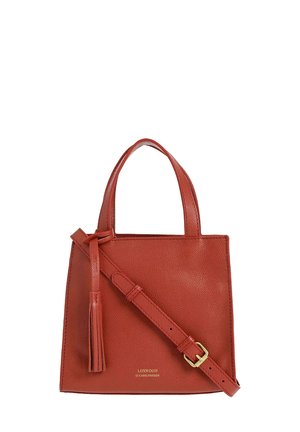 Sac à main en cuir rouge avec une forme structurée, deux poignées courtes, une bandoulière ajustable et un accent en gland. Quincaillerie dorée et détails du logo.