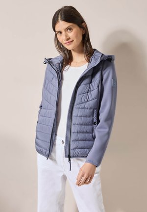 Veste rembourrée bleu-gris avec capuche, dotée d'une fermeture éclair et d'un accent au niveau des épaules. Mélange de matériaux avec des textures lisses et matelassées.