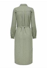 Abito camicia in lino verde con maniche lunghe, polsini abbottonati, colletto e vita con cintura. Presenta un yoke posteriore e orlo dritto.