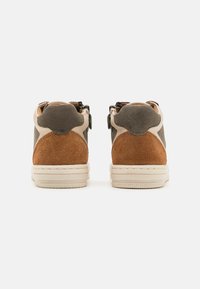Sneakers med en blandning av texturerat grått läder, bruna mockadetaljer, krämfärgad mellansula och slitstark gummisula; inkluderar dubbla remmar för stängning.