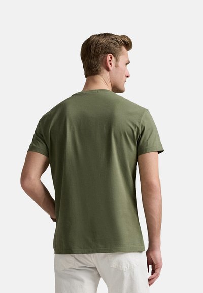 Camiseta de algodón verde oliva con mangas cortas, cuello redondo y una textura suave, vista desde la parte de atrás. Sin características o patrones prominentes.