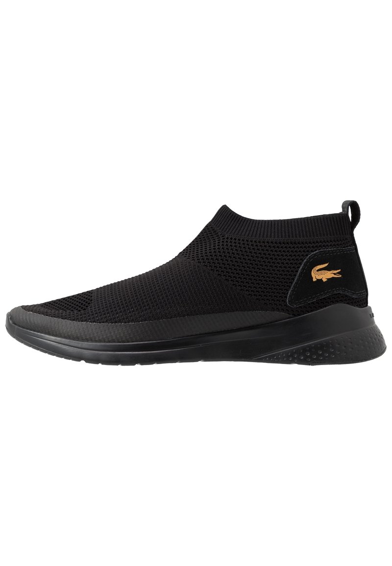 Sneaker nera slip-on con tomaia in mesh testurizzato, suola in gomma e un piccolo logo dorato sull'inserto del tallone. Design a bassa apertura con collare elastico.