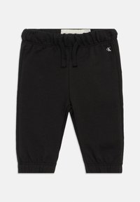 Μαύρο βαμβακερό παντελόνι φόρμας με ελαστική ζώνη στη μέση και κορδόνι. Περιέχει συγκεντρωμένα μανίκια και μικρό λογότυπο CK μπροστά.