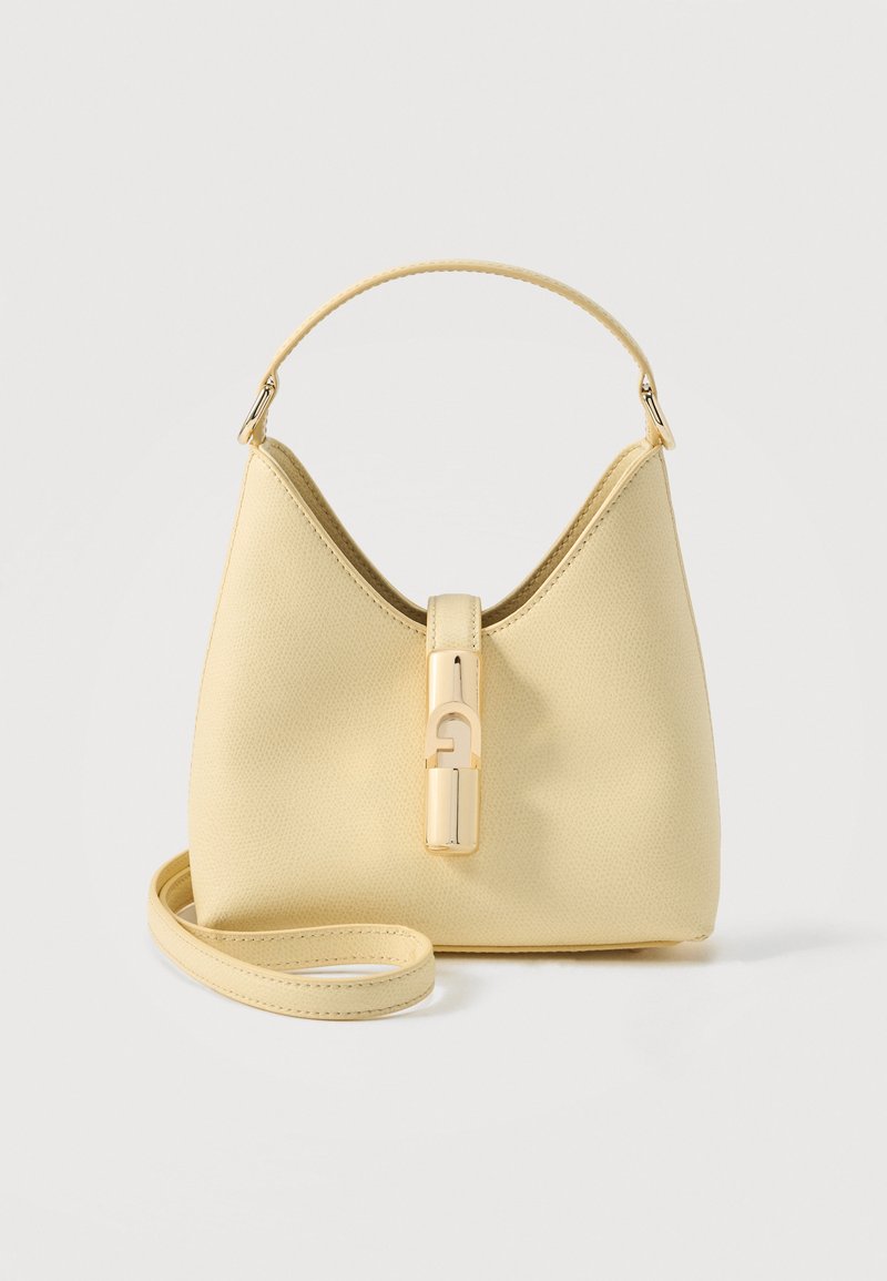 Sac à main en cuir beige avec une poignée unique sur le dessus, une bandoulière amovible et une fermeture à boucle dorée à l'avant.