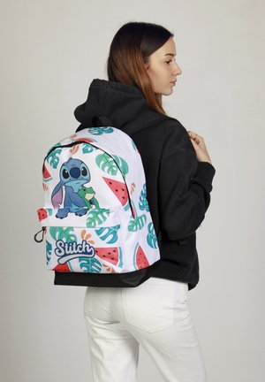 Weißer Rucksack mit bunten tropischen Mustern, der eine Grafik von Stitch zeigt, der einen Frosch hält. Enthält einen Reißverschluss und eine Vorderatsche.