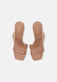 Nude-kleurige sandalen met vierkante neus, transparante banden en een gevoerd voetbed. Voorzien van het ALDO-logo in goud op de binnenzool.