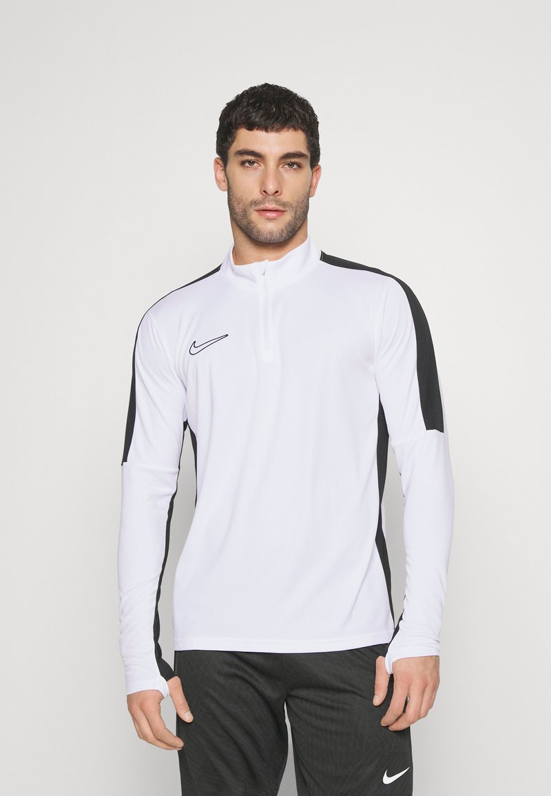 Top sportiv cu mâneci lungi și guler înalt, de culoare albă, cu panouri laterale negre și logo-ul Nike. Fabricat dintr-un material neted, elastic, care absoarbe umiditatea.