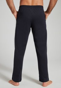 Juodos spalvos medvilninės kelnės su elastine juosmens dalimi, tiesių kojų kirpimo, be matomų kišenių, matomos iš nugaros. Lygus audinys.