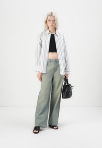 Raitapaita, musta crop top, vaaleanvihreät leveälahkeiset farkut ja musta teksturoitu käsilaukku. Avoinvarvassandaalit mustana.