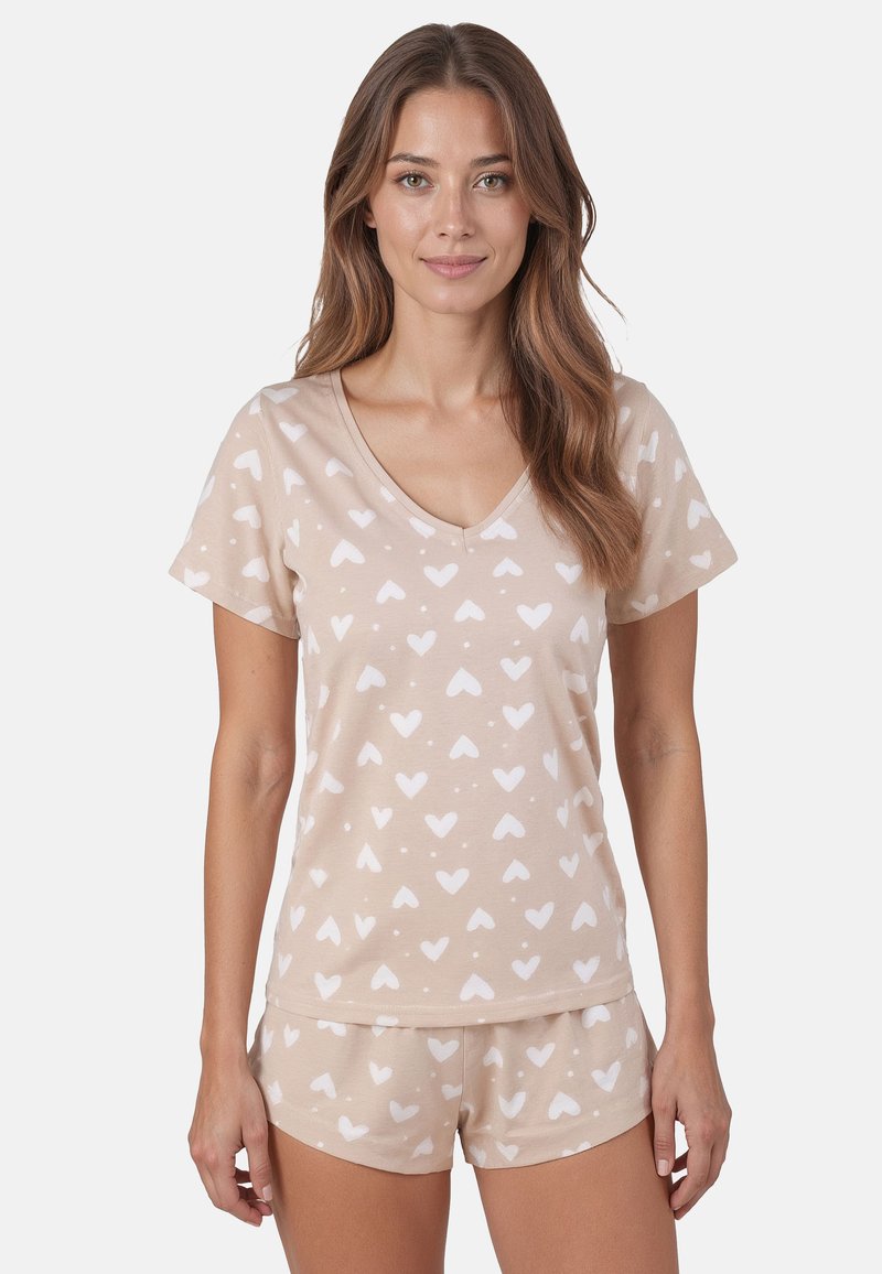 Beige Schlafanzug-Set mit kurzen Ärmeln und V-Ausschnitt. Mit einem Herzmuster in Weiß. Aus weichem, leichtem Stoff gefertigt, mit lässig geschnittenen Shorts.