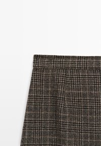 Spódnica z wełny z wysokim paskiem w talii, z szaro-brązowym wzorem w kratkę, teksturowanym materiałem i dopasowanym krojem.