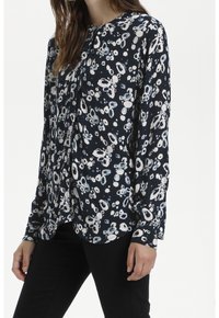 Långärmad blus i marinblått med ett blommönster i blått och vitt, med knappstängning och en avslappnad passform. Strukturerad tyg med subtila ribbor.