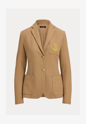 Beige blazer i teksturert stoff, med to gullknapper og en brystlomme med brodert logo i gull. Inkluderer to frontlommer.