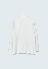 Bílý blazer s dlouhými rukávy, hladkou texturou a vystřiženým límcem. Má rovný střih a minimalistický design, bez viditelných zapínání.