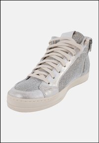 Zapatilla alta hecha de materiales texturizados plateados, con cordones de color claro, un cierre lateral y una suela blanca resistente.