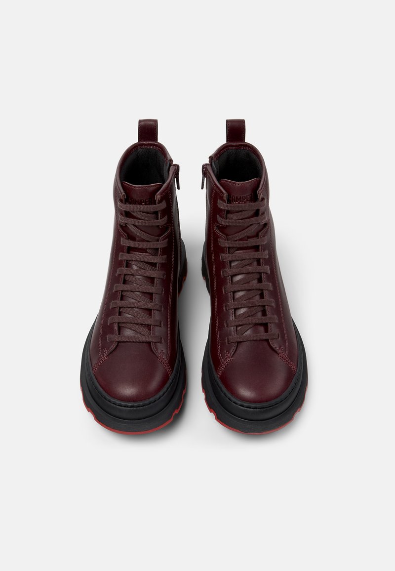 Bordeaux leren enkelbooties met grijze veters, zwarte rubberen zolen en rode accenten. Voorzien van hoge schachten en een achterste lus voor gemakkelijk aan- en uittrekken.