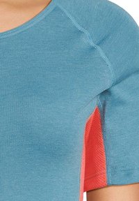 Maglietta atletica a maniche corte con corpo blu e pannelli laterali in rete corallo a contrasto, realizzata in tessuto traspirante e dalla texture piacevole.