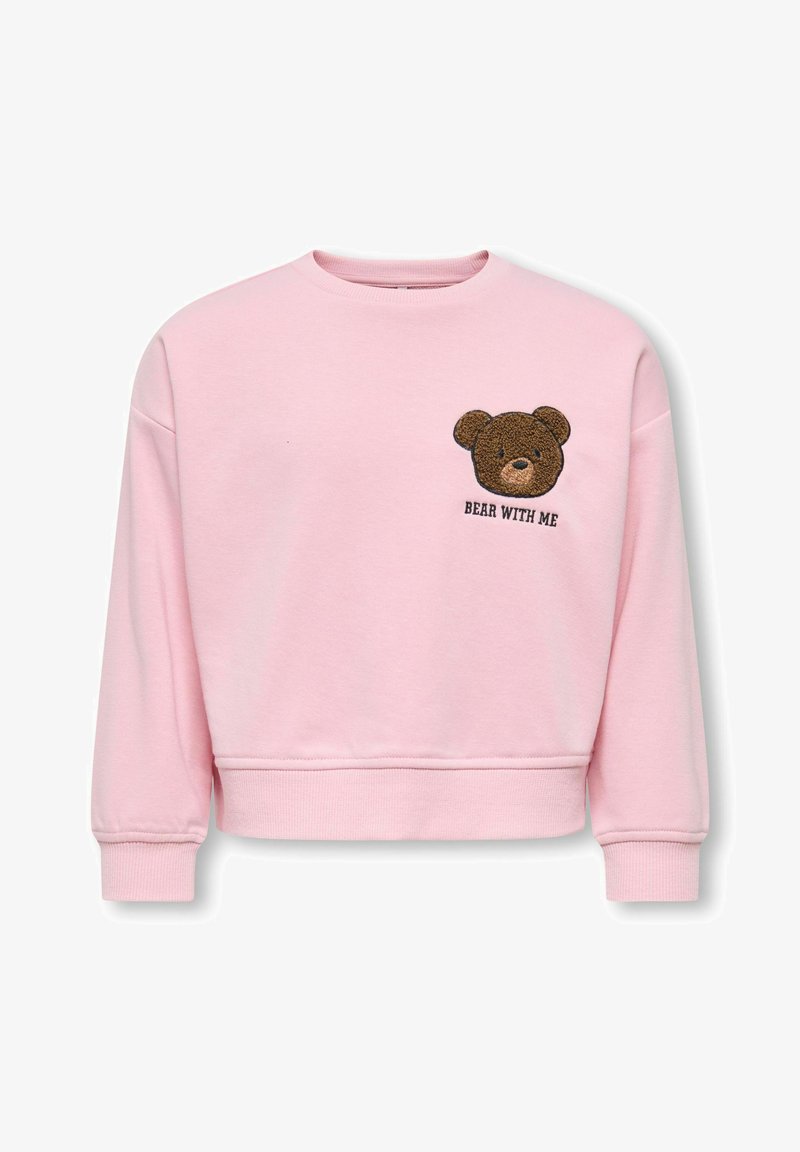 Lyserød sweatshirt med lange ærmer og ribbet kant. Har en brun bamse broderet på brystet med teksten "BEAR WITH ME".