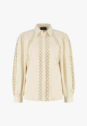 Crèmekleurige blouse met puntige kraag, lange pofmouwen en verticale kantpanelen aan de voorkant en mouwen.