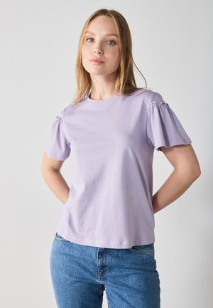 Lila Baumwoll-T-Shirt mit kurzen puffärmel, Rundhalsausschnitt und lässiger Passform. Getragen mit blauen Denim-Jeans. Glatte Textur, lässiges Design.