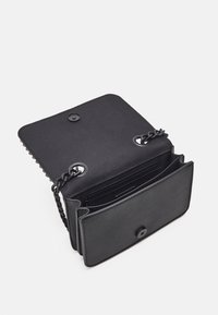 Svart handväska med en slät läderutsida, kedjerem, framficka med tryckknappsstängning och inre fack för organisering.