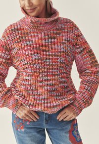 Mitmevärviline lõngast kampsun roosa, oranži ja pruunide toonidega. Omaduseks kõrge sooniline krae ja tekstuurse lõnga muster. Mugav lõige.