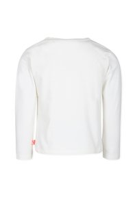 Chemise blanche à manches longues en coton doux. Dotée d'un col rond et d'un design minimaliste avec une petite étiquette rose sur le côté.