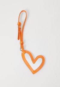 Orange hjärtformad nyckelring i glänsande material, med en utskuren mitten och ett ögleband för fäste. Detaljerad sömnad som accentuerar designen.