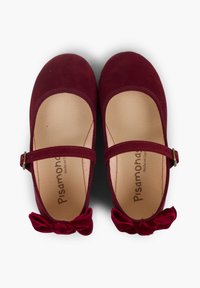 Ballerine in camoscio bordeaux con punta tonda, cinturino regolabile con fibbia e un fiocco decorativo sul tallone. Fodera interna morbida.