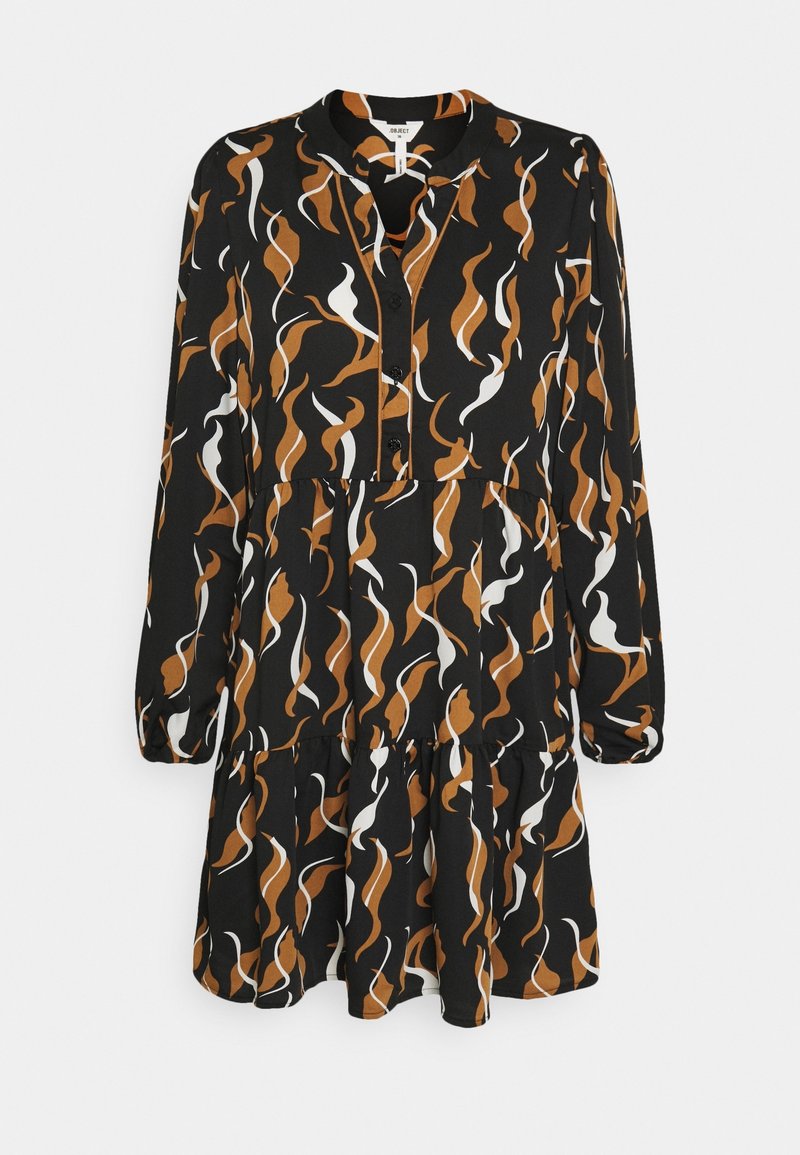 Robe noire avec un motif ondulé en nuances de brun et blanc, manches longues, fermeture à boutons et ourlet évasé. Fabriquée en tissu léger.