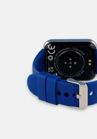 Slimwatch met een rechthoekige wijzerplaat, zwarte achterkant, blauwe siliconen band, zilveren metalen gesp en oplaadconnectoren aan de achterkant.