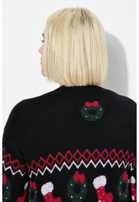 Schwarzer Pullover mit einem Weihnachtsdesign, das grüne Kränze und rote Strümpfe zeigt. Strickgewebe, runder Ausschnitt und festliche Muster.