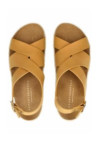 Hnědé kožené sandály s křížovými pásky, korkovou stélkou a nastavitelnou sponou. Podešev má strukturovaný bílý okraj.