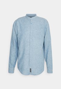 Chemise à manches longues bleu clair en tissu texturé, avec un col montant, cinq boutons et une poche sur la poitrine gauche.