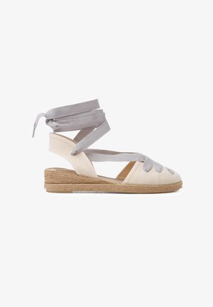 Espadrille-Sandalette mit Obermaterial aus beigem Canvas, grauen Ribbons und einem mit Jute umwickelten Keilabsatz. Offenes Zehen-Design mit Kreuzdetails.