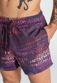 Plavky z lehkého materiálu s gradientním vzorem v tmavě purpurové a červené, s elastickým pasem na šňůrku a kapsou.