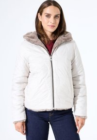 Chaqueta acolchada de color beige claro con cierre de cremallera, capucha forrada de piel sintética y puños en tono topo. Cuenta con bolsillos laterales y un ajuste relajado.