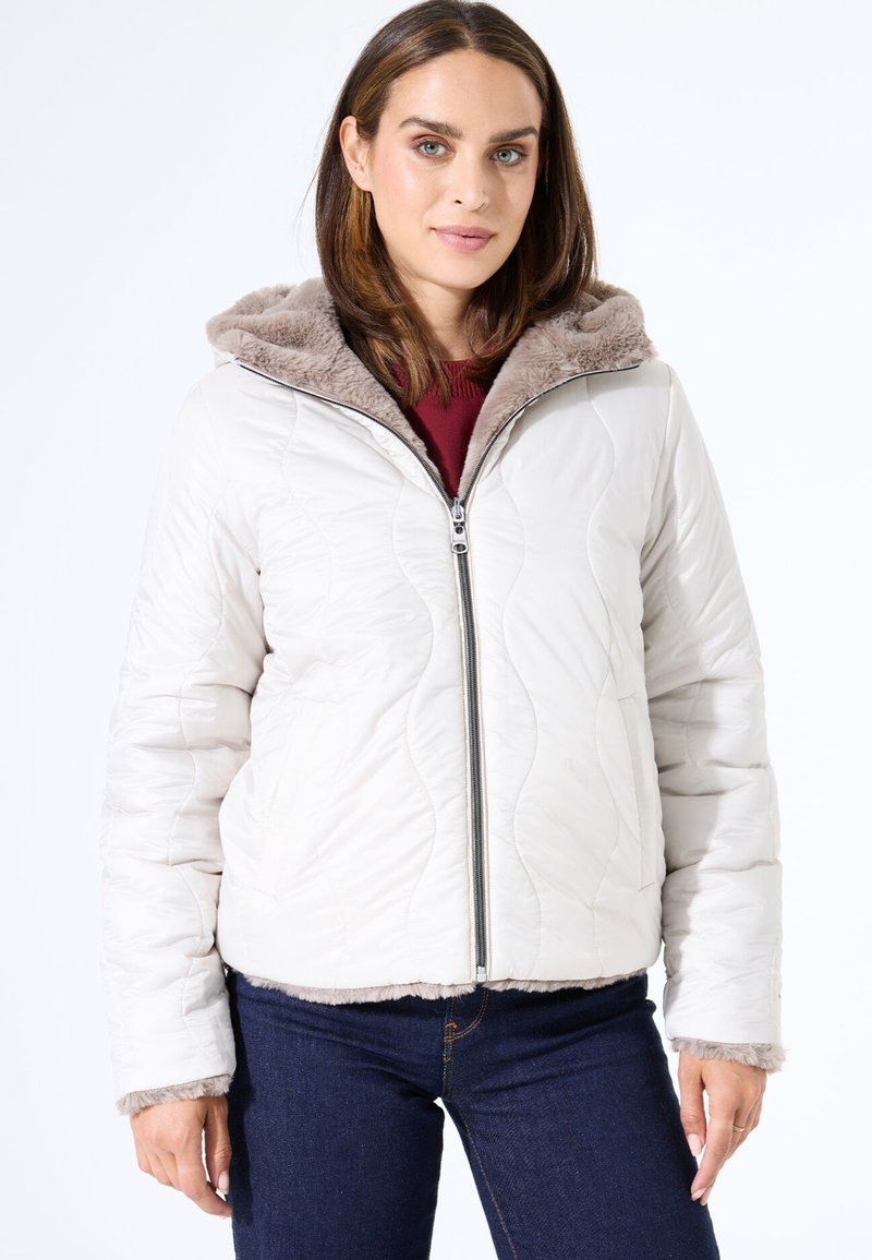 Chaqueta acolchada de color beige claro con cierre de cremallera, capucha forrada de piel sintética y puños en tono topo. Cuenta con bolsillos laterales y un ajuste relajado.