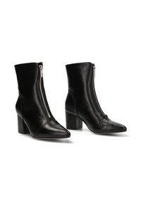 Botas de cuero negro hasta el tobillo con cremallera lateral, diseño de punta afilada, tacón cuadrado y una textura suave. Acentuadas con un detalle de costura en la punta.