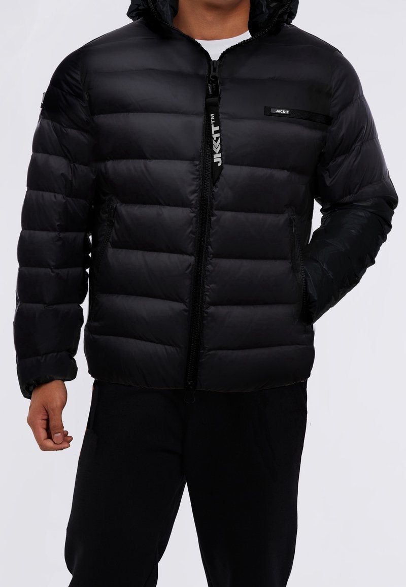 Zwarte pufferjas met capuchon, voorzien van een ritssluiting, horizontaal doorgestikt ontwerp, twee zijzakken en logo-accenten op de borst.