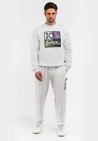 Light grey sweatshirt with multicolored "ICE" and "Iceberg" graphic. Paired with matching light grey sweatpants featuring black text detail.