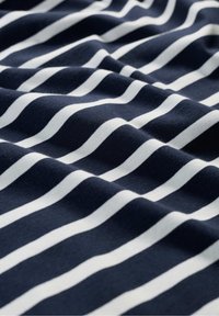 Marinblått tyg med vita horisontella ränder, med en mjuk textur och subtil fall, lämpligt för olika klädesapplikationer.