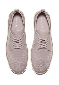 Zapatillas de punto morado claro con acentos de cuero, puntera redonda, diseño con cordones, superficie texturizada y suela de goma blanca.