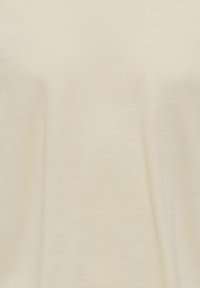 Jasno beżowy t-shirt z bawełny o gładkiej fakturze i minimalnym rozciągnięciu. Materiał wydaje się lekko melanżowy, bez widocznych wzorów czy akcentów.