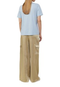 Lichtblauw katoenen t-shirt met korte mouwen, gecombineerd met beige satijnen cargo broek met twee zijzakken en een losse pasvorm.