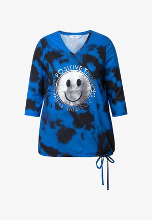 Blå og sort tie-dye V-hals top med trekvart ærmer, der har et sølvfarvet smilende ansigt og teksten "POSITIVE THINKING." Justerbar snor i kanten.