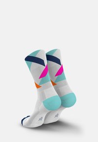 Colorful ankle socks featuring geometric patterns in pink, orange, navy, and turquoise on a white base; textured fabric.